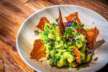 guacamole plate with nachos on a white dish