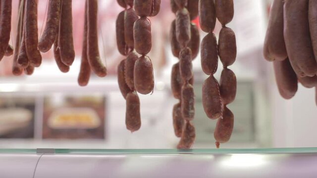 meat hanging from charcuterie inside a market