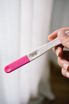 Anonymous female holding a pregnancy test