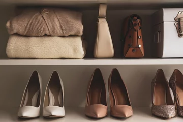 Fotobehang Stylish women's shoes, clothes and bags on shelving unit © New Africa