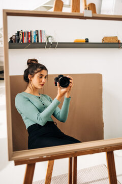 Photographer with photo camera against mirror at home