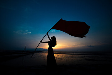 旗を持つ女性のシルエット