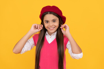 happy teen school girl in french beret on yellow background, beauty