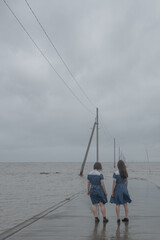 海辺に立つ女子高生の後ろ姿