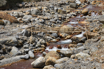 Bamboo bridge over high current himalyan river .