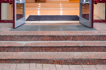 marble staircase with granite steps to entrance door on store with glass, threshold with doormat at...