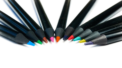 Colored pencils lying in a semicircle on a white background.