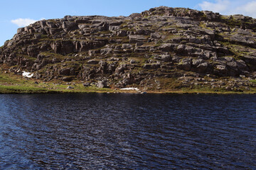 northern lake with clear water against the background of rocky hills