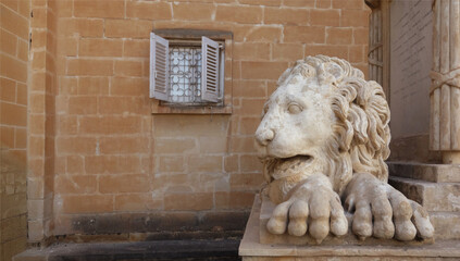 lion statue in front of the church window, Valetta, Malta