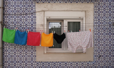 clothes hanging on a clothesline in a traditional window, Lisbon, Portugal