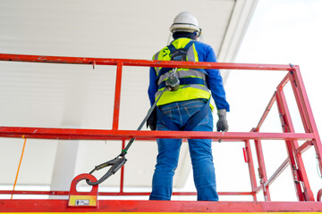 Worker on a Scissor Lift Platform working at site focus on full harness safety belt	