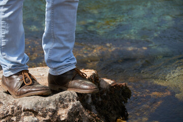 Low angle view of man standing on the rocky cliff, travel concept