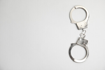 Classic chain handcuffs on white background, top view. Space for text