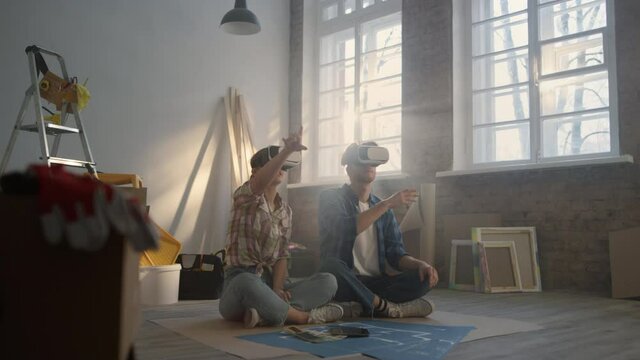 Serious family sitting in vr glasses on floor. Couple making project in 3d.