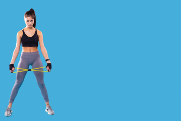 Focused young athlete woman making sport training alone with sports equipment doing exercise standing on the floor.