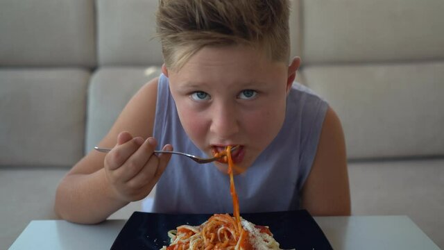 Niño comiendo espaguetis plano medio