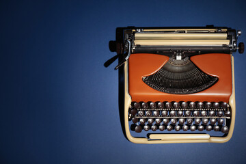 Fototapeta na wymiar Vintage typewriter on dark blue background, top view. Space for text