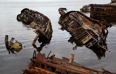 rusty skeletons of submerged schooners on the picturesque seashore. Kola peninsula Teriberka
