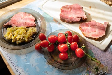 Cherry tomato, sliced smoked meat and meat with potato.