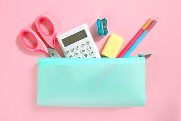 School supplies set top view on pink empty space background. Pencil case with accessories. Back to...