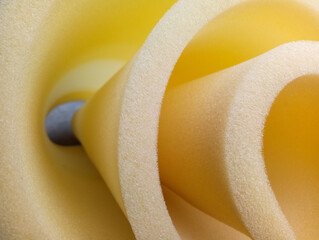 Circular yellow foam sponge.
 yellow sponge foam material rolled in a spiral shape or funnel