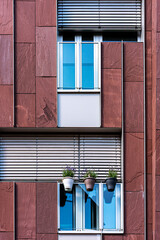Blumentöpfe an kahler Hausfassade