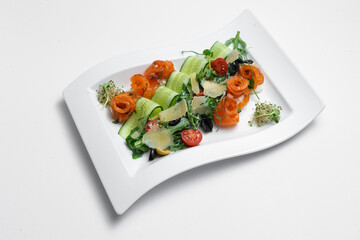 closeup of salad with lightly salted salmon and vegetables on white background