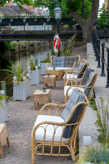 selective focus view of an idyllic waterfront patio of a restaurant with lounge chairs and small tables