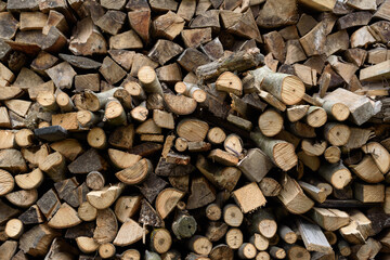 Wall of firewood, background of dry chopped firewood. Alternative fuel concept. Wooden background. Natural texture.