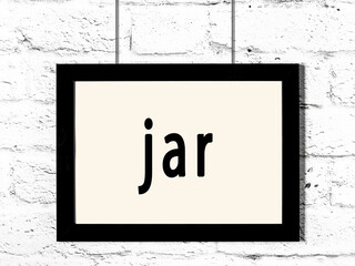 Black frame hanging on white brick wall with inscription jar