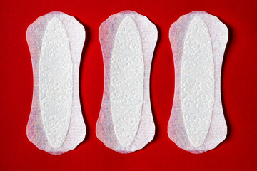 Feminine hygiene panty liner for menstruation. Menstrual cycle, pad. red background.