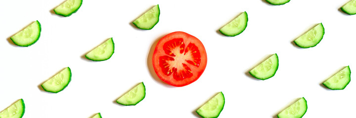 repeating pattern of sliced semicircles of fresh raw vegetable cucumbers for salad and a slice of tomato in the center isolated on a white background flat lay, top view. banner
