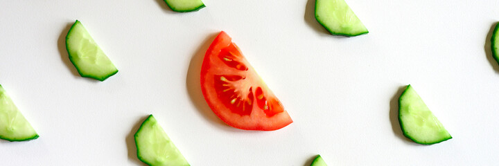 repeating pattern of sliced semicircles of fresh raw vegetable cucumbers for salad and a slice of tomato in the center isolated on a white background flat lay, top view. banner