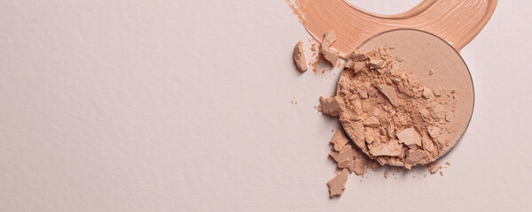 Crushed beige face finishing and liquid powder. Macro texture of make-up on beige background