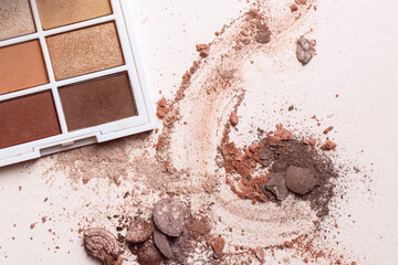 Crushed eyeshadows and eyeshadow palet. Macro texture of make-up on beige background - obrazy, fototapety, plakaty