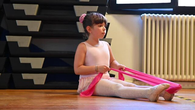 little girl in the ballet studio. The child does stretching before dancing lessons. Contemporary studio. High quality 4k footage