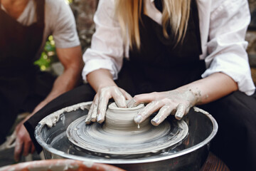 People making a vaze from a clay on a pottery's machine