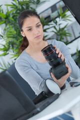 female photographer checking camera lens