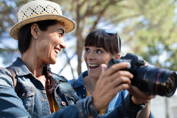 female photographers watching photos on a new slr camera
