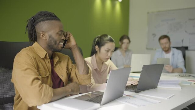 Office worker having loud phone conversation at work, disturbing other employees