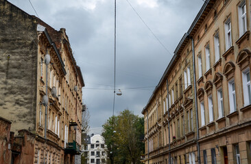 Streetscape street of historic Lviv city during day with yellow old vintage buildings in local residential neighborhood alley in old town