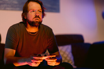 Mann spielt zu Hause ein Computerspiel mit einem Controller 