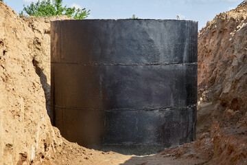 For laying water pipes in a trench with wooden stakes to indicate the direction and height, a concrete well covered with waterproofing mastic was prepared