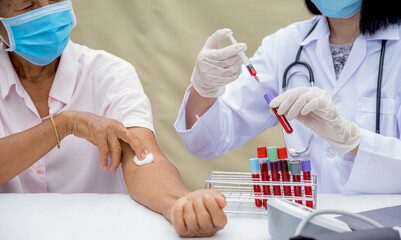 A doctor hands with a syringe and a sample of blood tube for analysis and test virus disease in the...