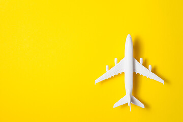 Flat lay design of travel concept with plane on yellow background with place for text.