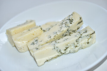 White cheese with blue mold on a white plate