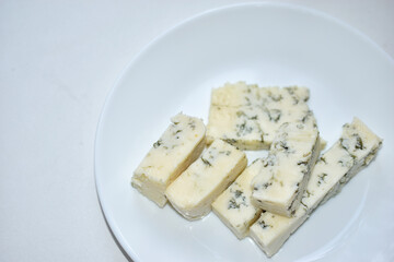 White cheese with blue mold on a white plate