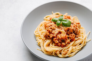 Traditional italian pasta spaghetti with bolognese meat sauce and parmesan on a light concrete, stone background. Close up