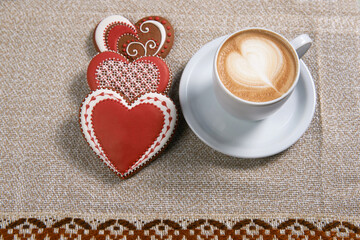 Valentines discount. Top view shot of cup of coffee next to heart shaped cookies with percentage written on one