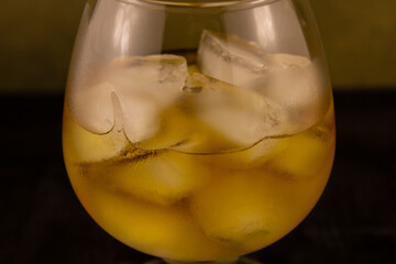 chilled glass of cognac with ice cubes